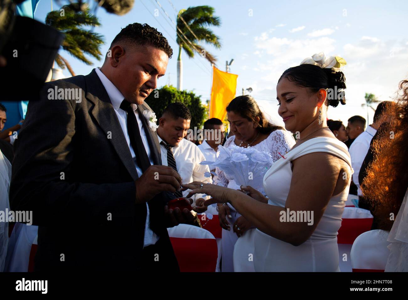 Un hombre pone un anillo de boda en el dedo de su novia durante una  ceremonia de boda masiva el día de San Valentín en Managua, Nicaragua el 14  de febrero de