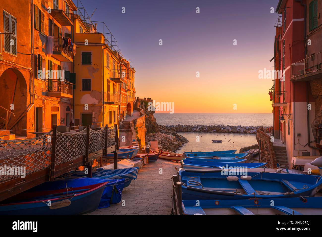 Riomaggiore pueblo de la calle, los barcos y el mar en el atardecer, Cinque Terre Parque Nacional, región de Liguria, Italia, Europa. Foto de stock