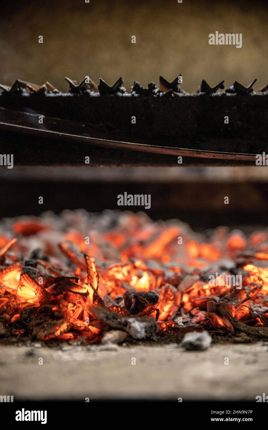 Cierre vertical del carbón en combustión en la parrilla. Foto de stock