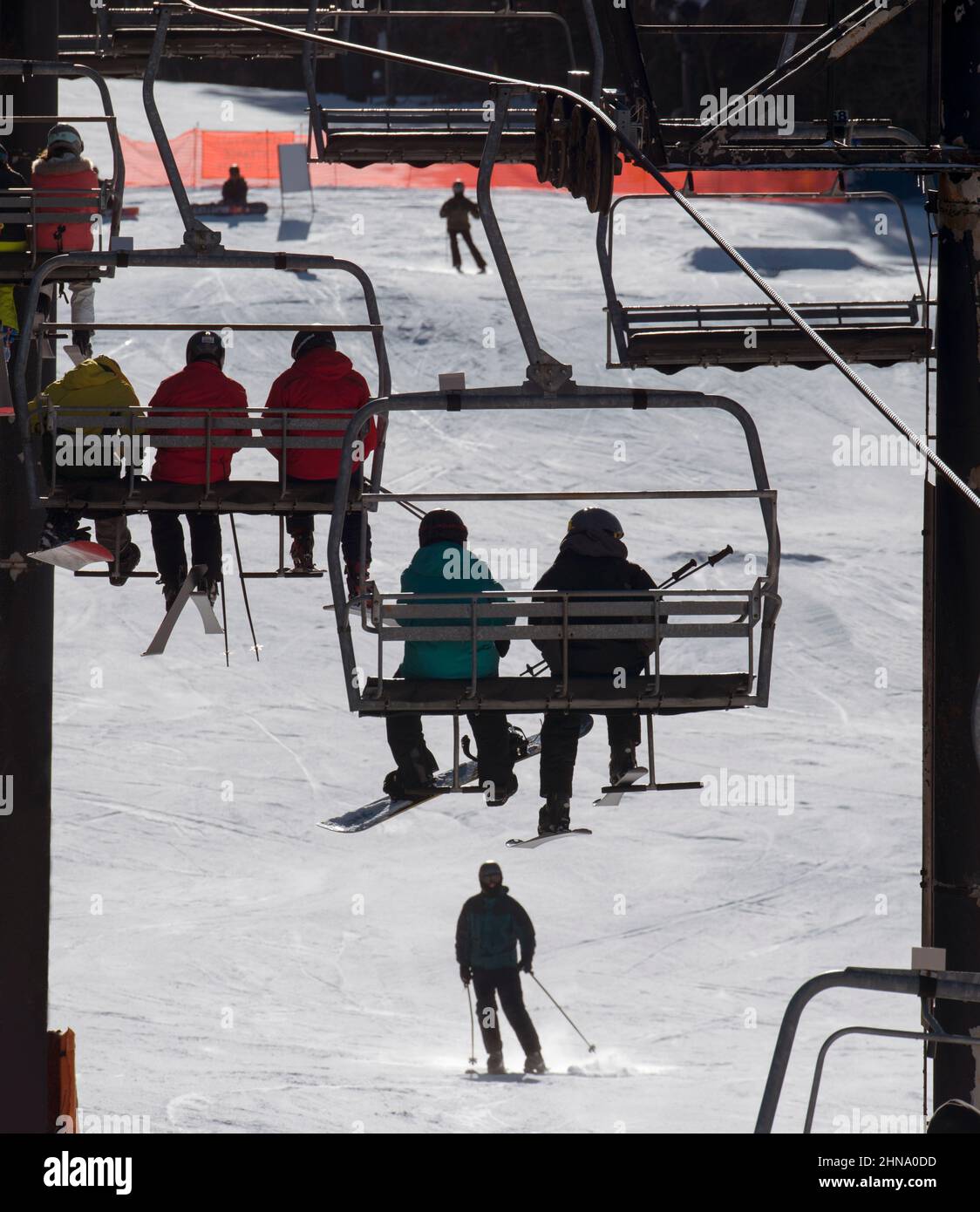 Los esquiadores y snowboarders recorren el telesilla Valley Quad en la zona de esquí de Crotched Mountain en el oeste de New Hampshire, Estados Unidos. Foto de stock
