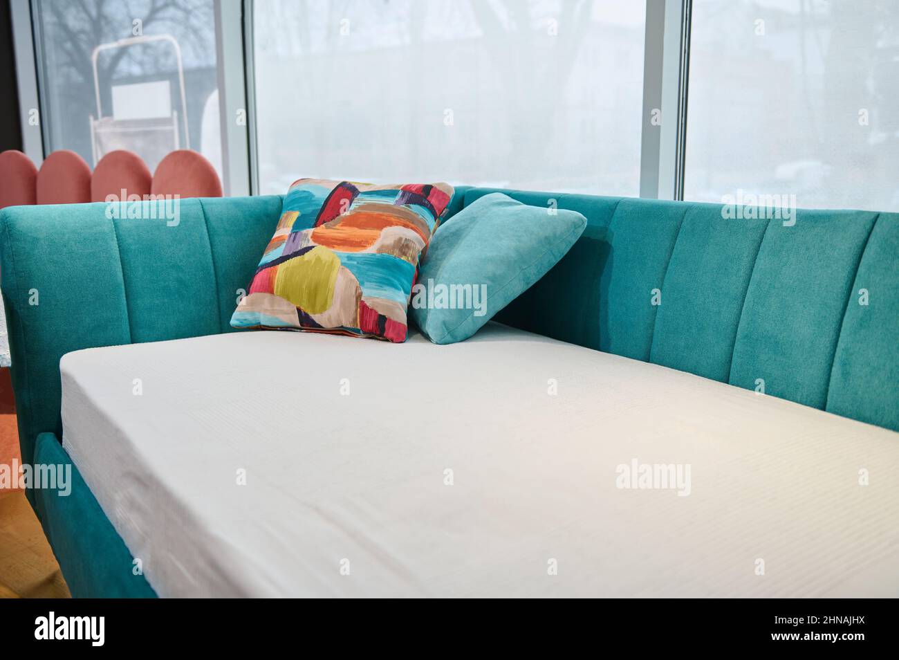 Primer plano. Sofá cama para niños moderno, elegante y minimalista, con un  suave tejido de terciopelo turquesa brillante, a la venta en la sala de  exposición de las montañas Fotografía de stock -