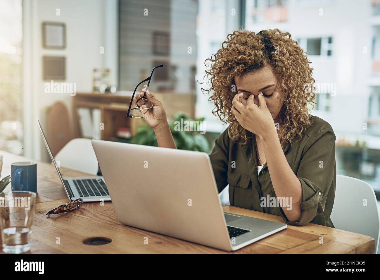 Cuando el camino hacia el éxito conduce al estrés. Disparo de una mujer  joven que sufre de estrés mientras usa una computadora en su escritorio de  trabajo Fotografía de stock - Alamy