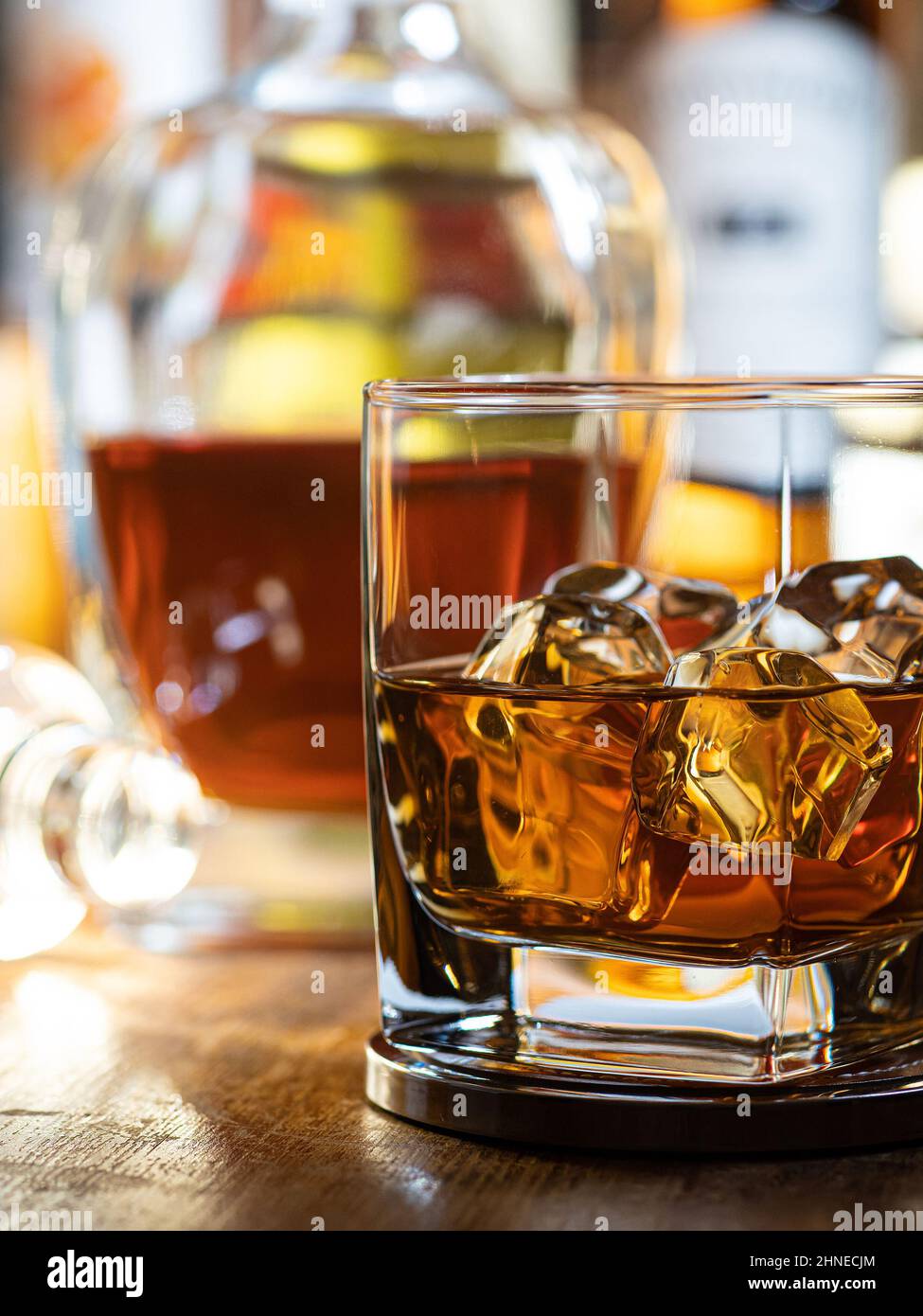 Vaso de whisky en las rocas en una barra de madera con botellas de fondo  Fotografía de stock - Alamy