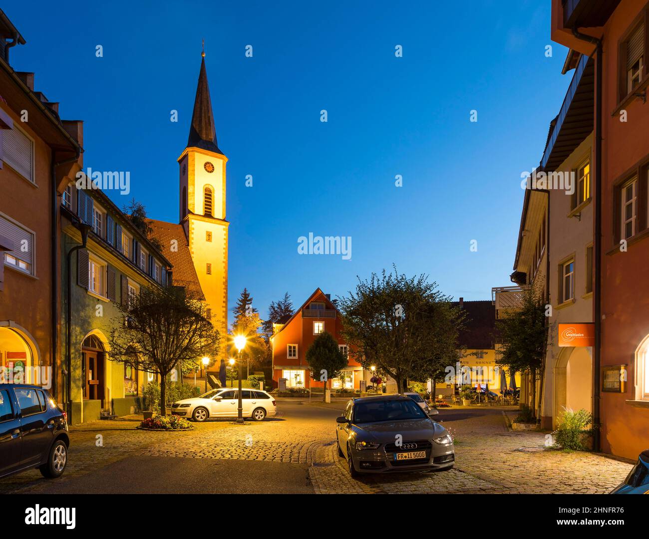 Kirchstrasse con Iglesia de San Miguel, fotografía al atardecer, Loeffingen, distrito de Breisgau-Hochschwarzwald, Baden-Württemberg, Alemania Foto de stock