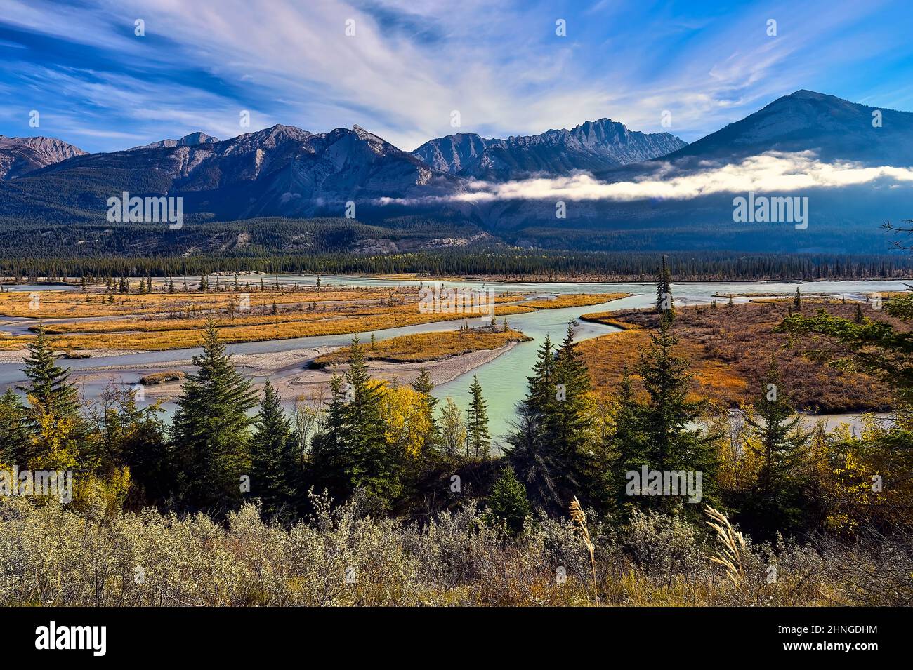 Una imagen de paisaje otoñal de las montañas rocosas y el río Athabasca con vegetación de color otoñal en el Parque Nacional Jasper en Alberta, Canadá Foto de stock