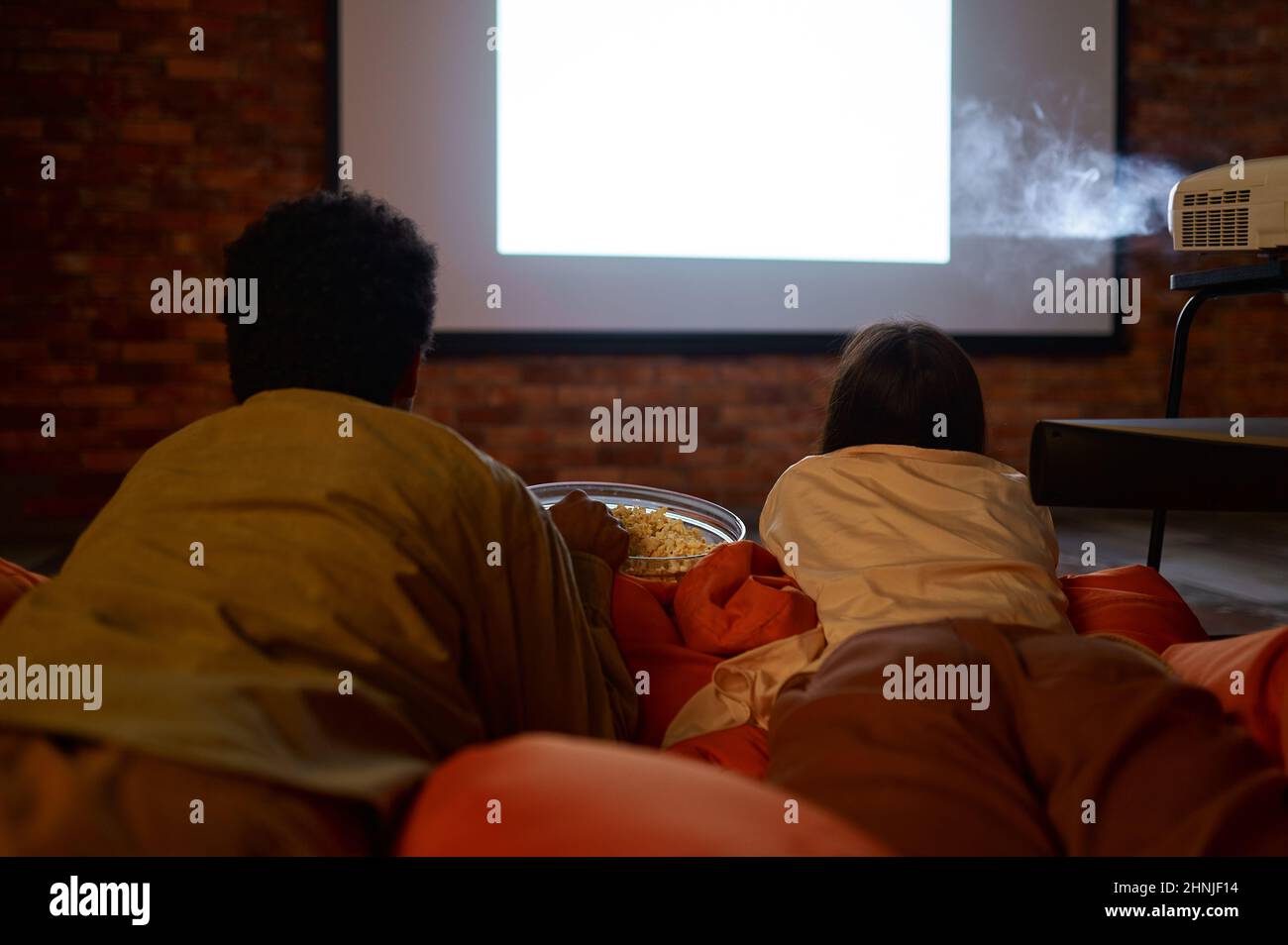 Una pareja tumbada en un bolso blando viendo el proyector Fotografía de  stock - Alamy