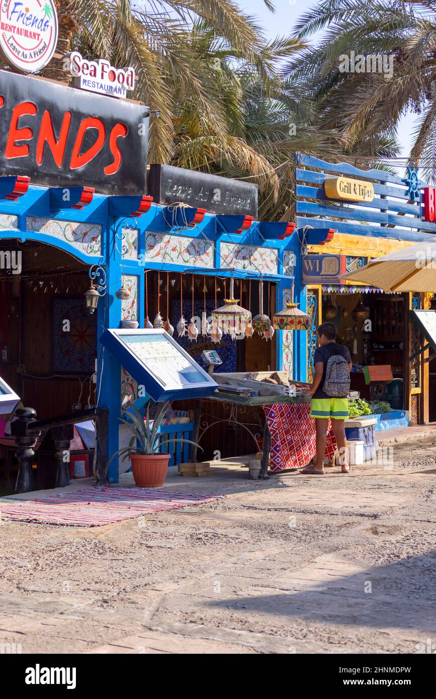 Paseo principal con tiendas y restaurantes, la vida cotidiana de un pequeño pueblo exótico en el Mar Rojo, Dahab, Egipto Foto de stock