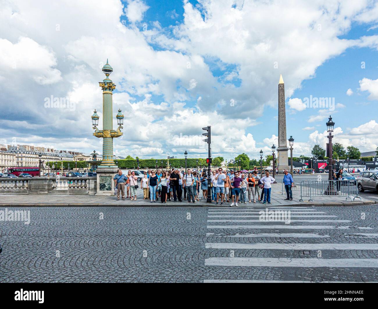 La gente cruza la calle en un semáforo para peatones en la Place de la concorde en el corazón de Paris.at Champs d'Elysees Foto de stock