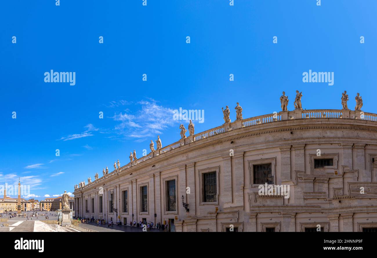 Los turistas visitan la Plaza de San Pedro en el Vaticano con los famosos edificios de Miguel Ángel en Roma, Italia Foto de stock