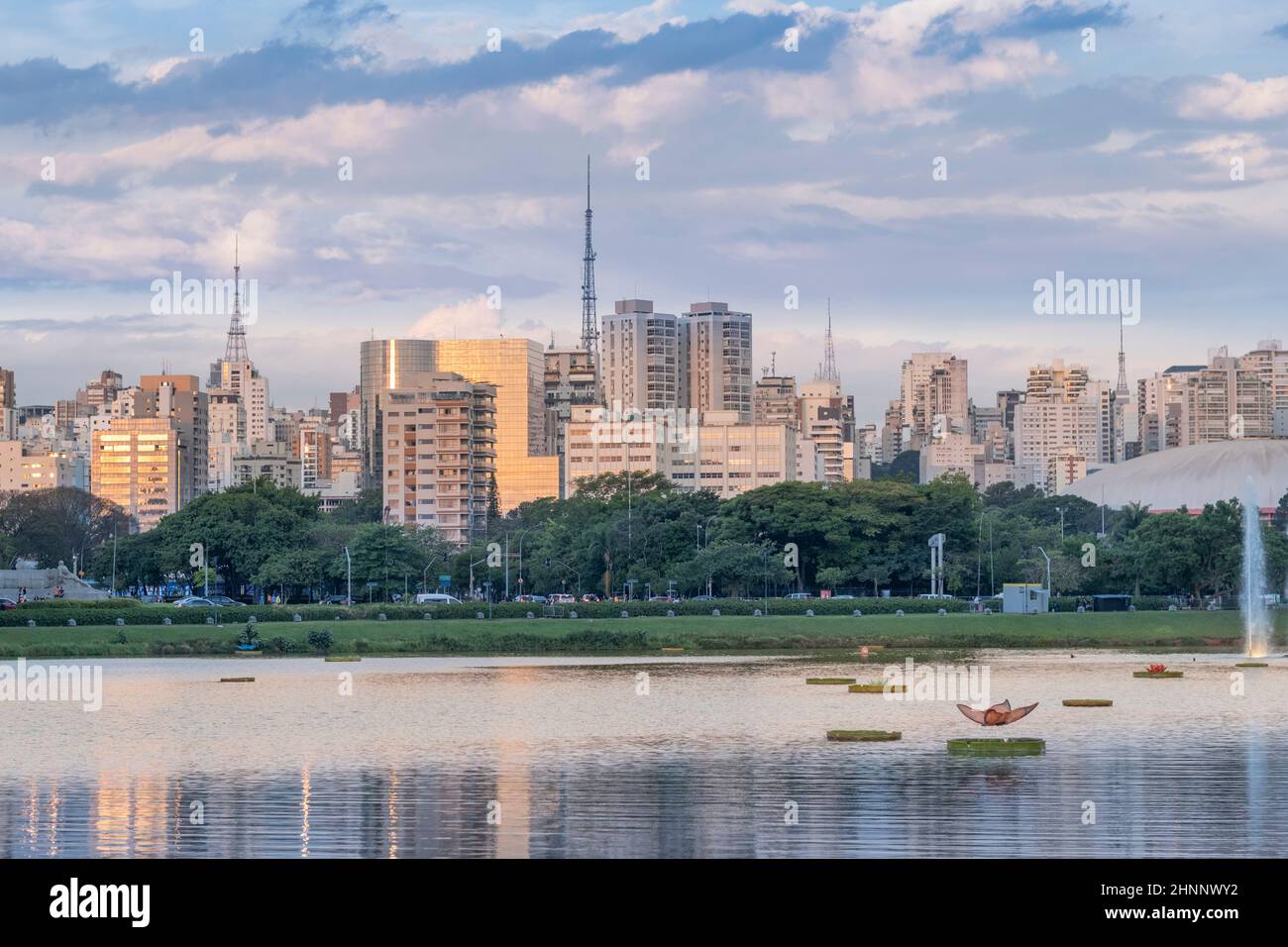 Brasil, Sao Paulo, Ciudad de Sao Paulo, Parque Ibirapuera y lago con el horizonte de la ciudad en la distancia Foto de stock