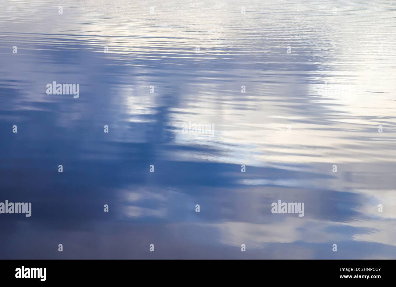 Vista detallada de primer plano sobre superficies de agua con olas y. ondas y la luz del sol que se refleja en la superficie Foto de stock
