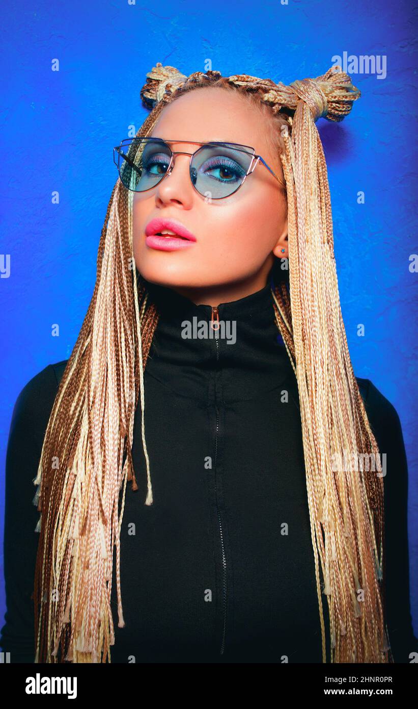 Mujer rubia con piercing y trenzas africanas en gafas de sol azules  Fotografía de stock - Alamy