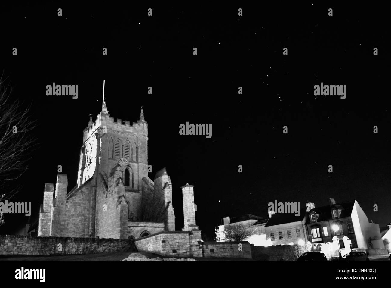 Imagen en blanco y negro de la Iglesia de San Hilda, Hartlepool, Reino Unido, con un impresionante cielo nocturno. Las estrellas brillan incluyendo la constelación de Orión. Foto de stock