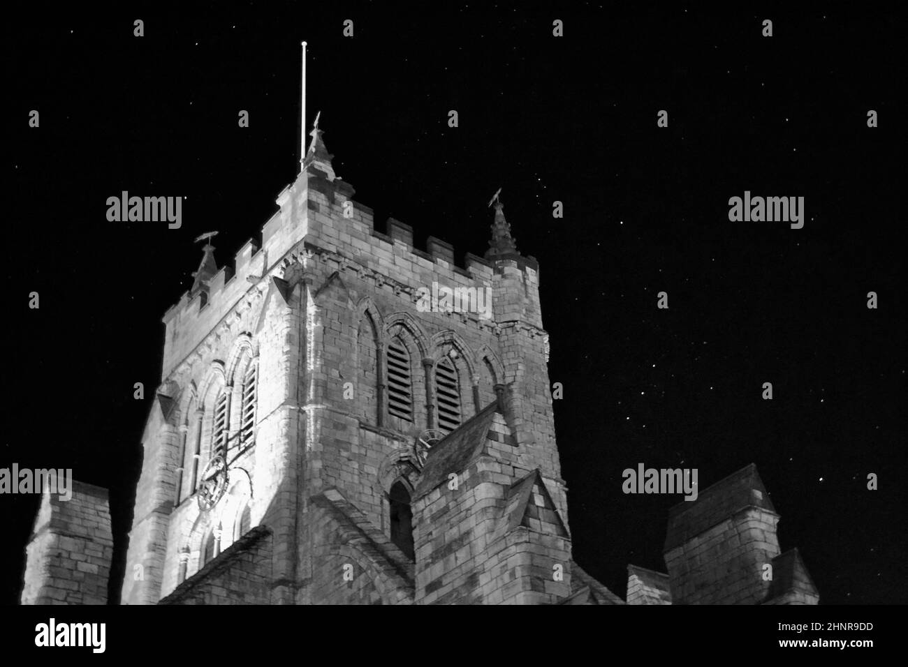 Imagen en blanco y negro de la Iglesia de San Hilda, Hartlepool, Reino Unido, con un impresionante cielo nocturno. Las estrellas brillan incluyendo la constelación de Orión. Foto de stock