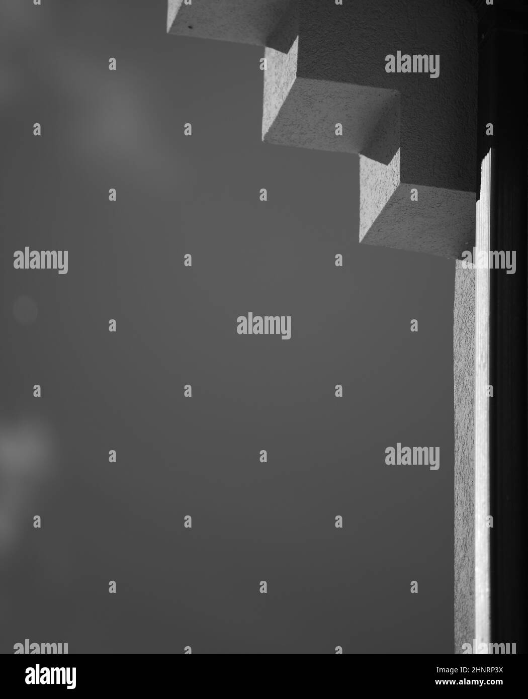 imagen en blanco y negro de las sombras en la esquina del techo del exterior del edificio con cielo abierto en fondo de formato vertical con espacio para el tipo Foto de stock