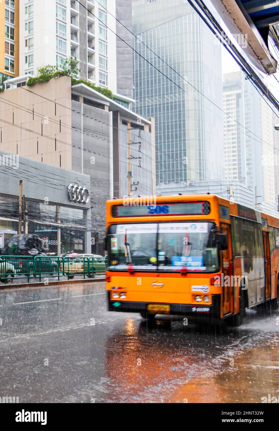 Típico autobús naranja de la ciudad con fuertes lluvias en Bangkok Tailandia. Foto de stock