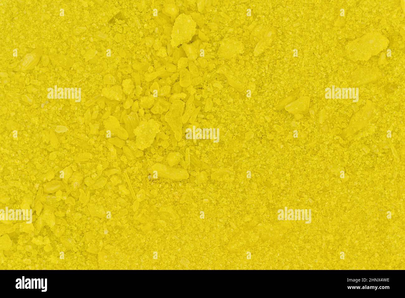 Pequeños cristales amarillos brillantes de cromato sódico, fotografía del microscopio, anchura de la imagen 16mm. Foto de stock