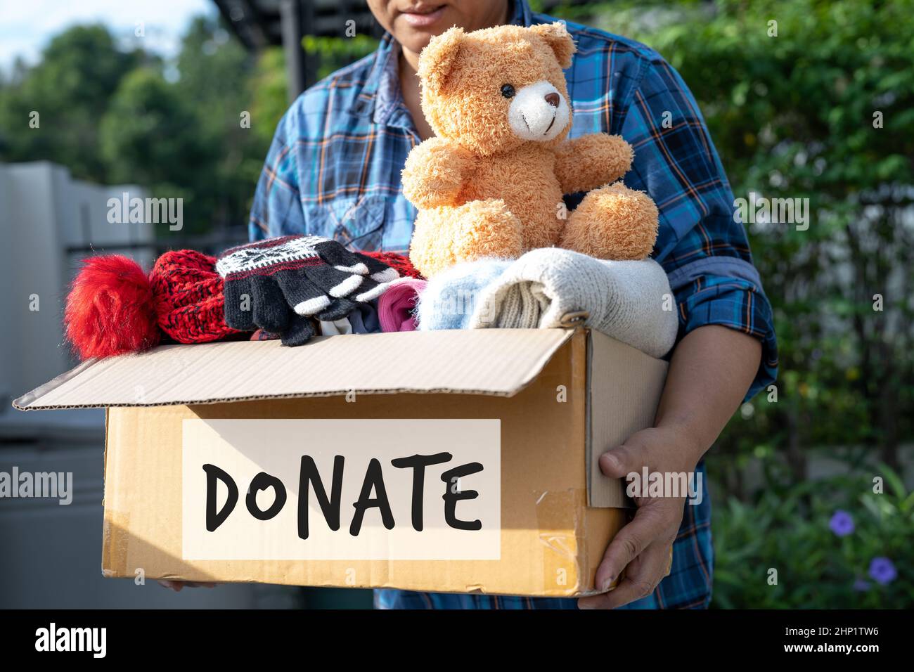 Llevar una caja de donación de ropa con ropa usada y muñeca en casa
