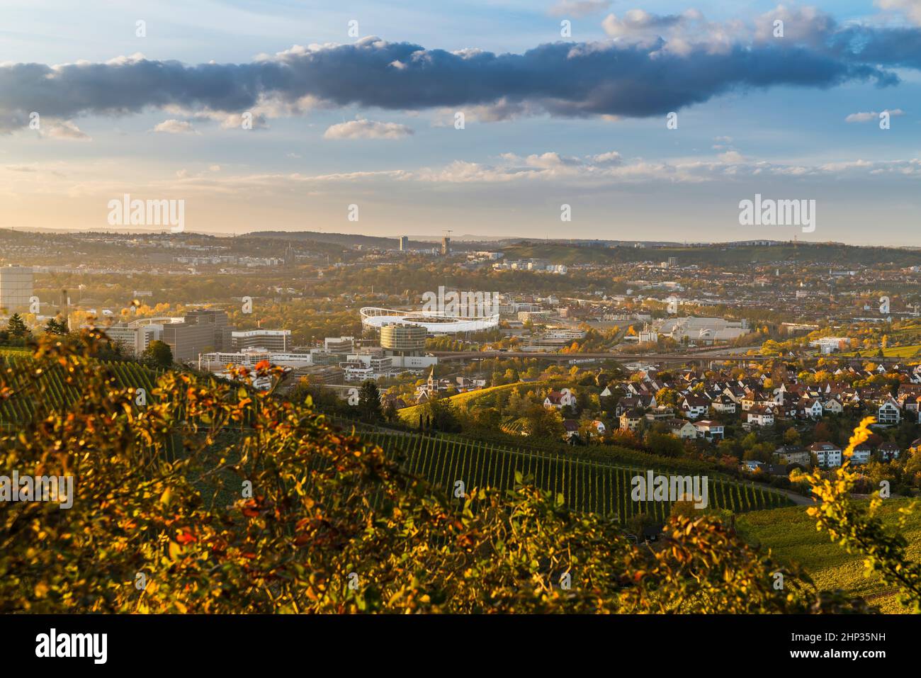 Alemania, ciudad de Stuttgart vista panorámica sobre el horizonte, autopista, paisaje, industria, casas, calles, estadio en la cuenca al atardecer Foto de stock