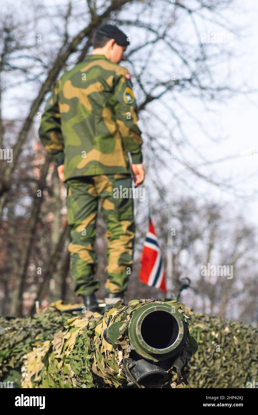 Tanque blindado del ejército noruego con revestimiento de cañón y camuflaje con soldado en él y bandera de Noruega, la fuerza de respuesta de la OTAN Foto de stock