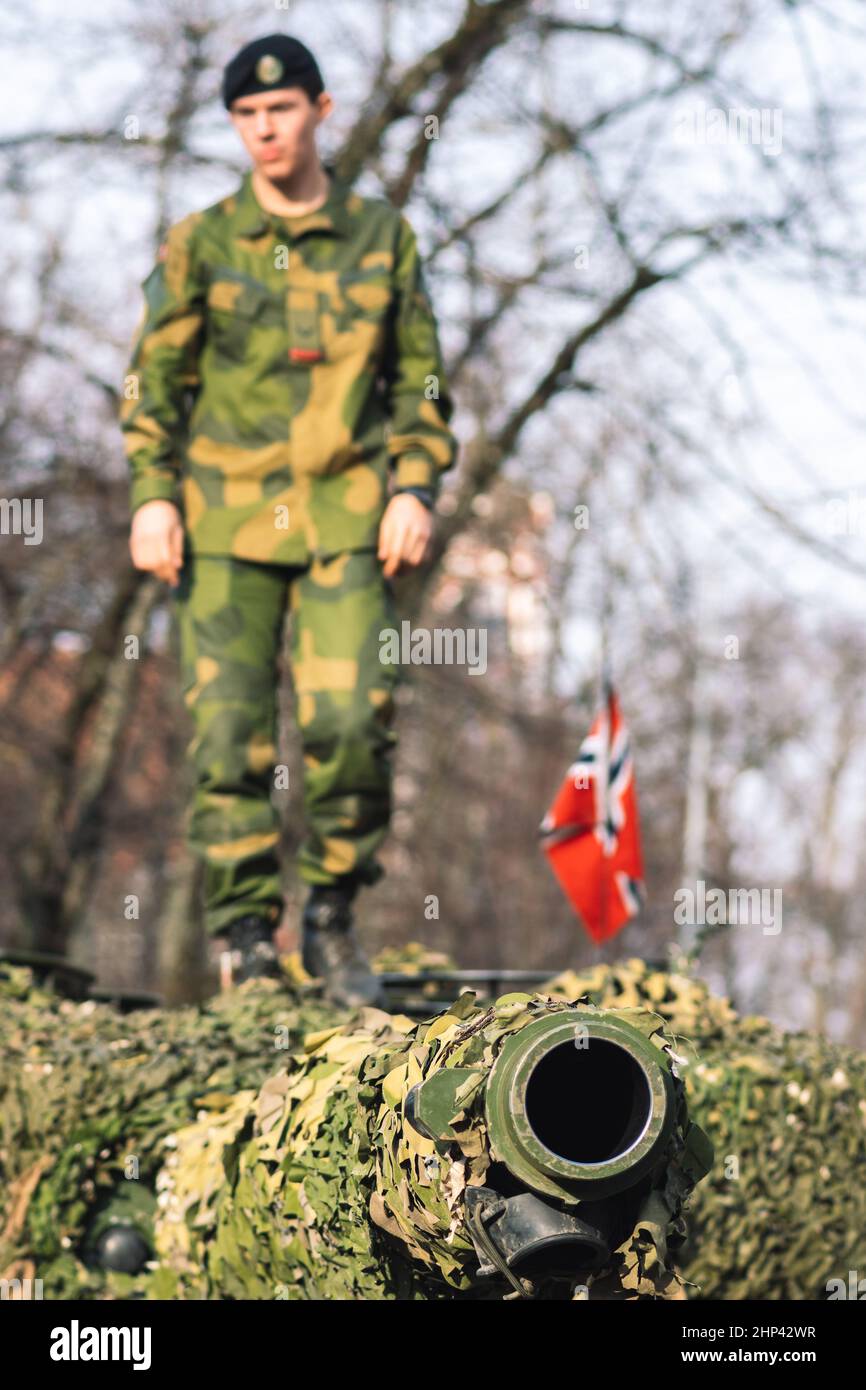 Tanque blindado del ejército noruego con revestimiento de cañón y camuflaje con soldado en él y bandera de Noruega, la fuerza de respuesta de la OTAN Foto de stock