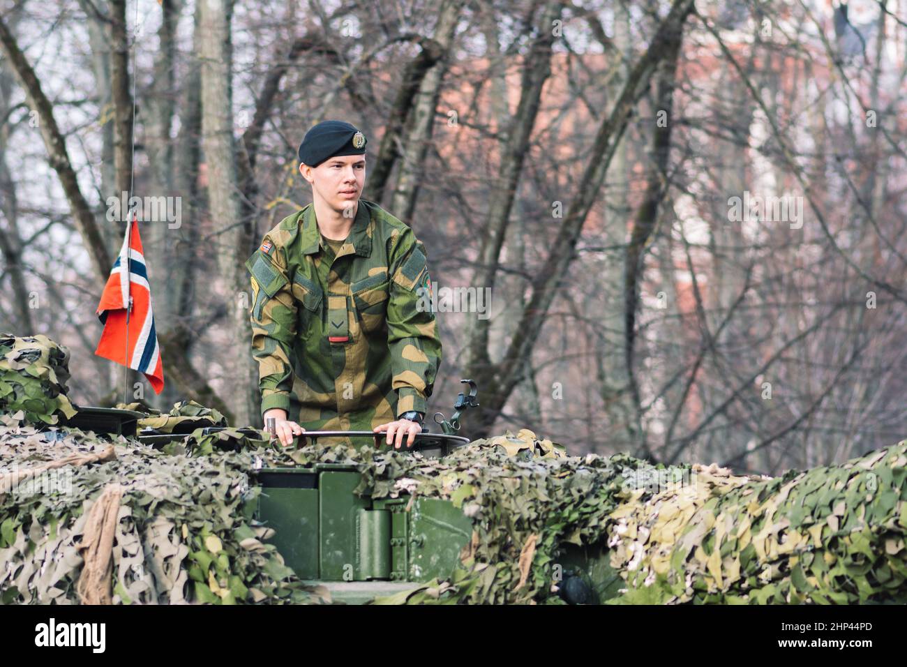 Tanque blindado del ejército noruego con revestimiento de cañón y camuflaje con soldado en él y bandera de Noruega, la fuerza de respuesta de la OTAN Foto de stock