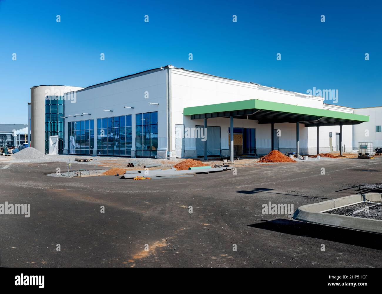Tiro horizontal de una gran tienda minorista de cajas grandes bajo construcción bajo un cielo azul. Foto de stock
