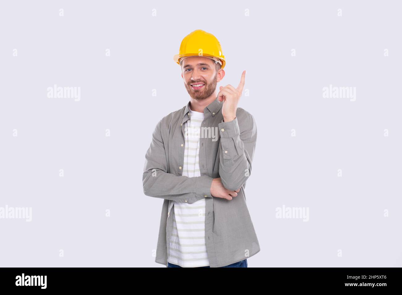 Trabajador de la Construcción teniendo una gran idea. Hombre con idea Suteniendo el dedo hacia arriba. Trabajador en casco aislado Foto de stock