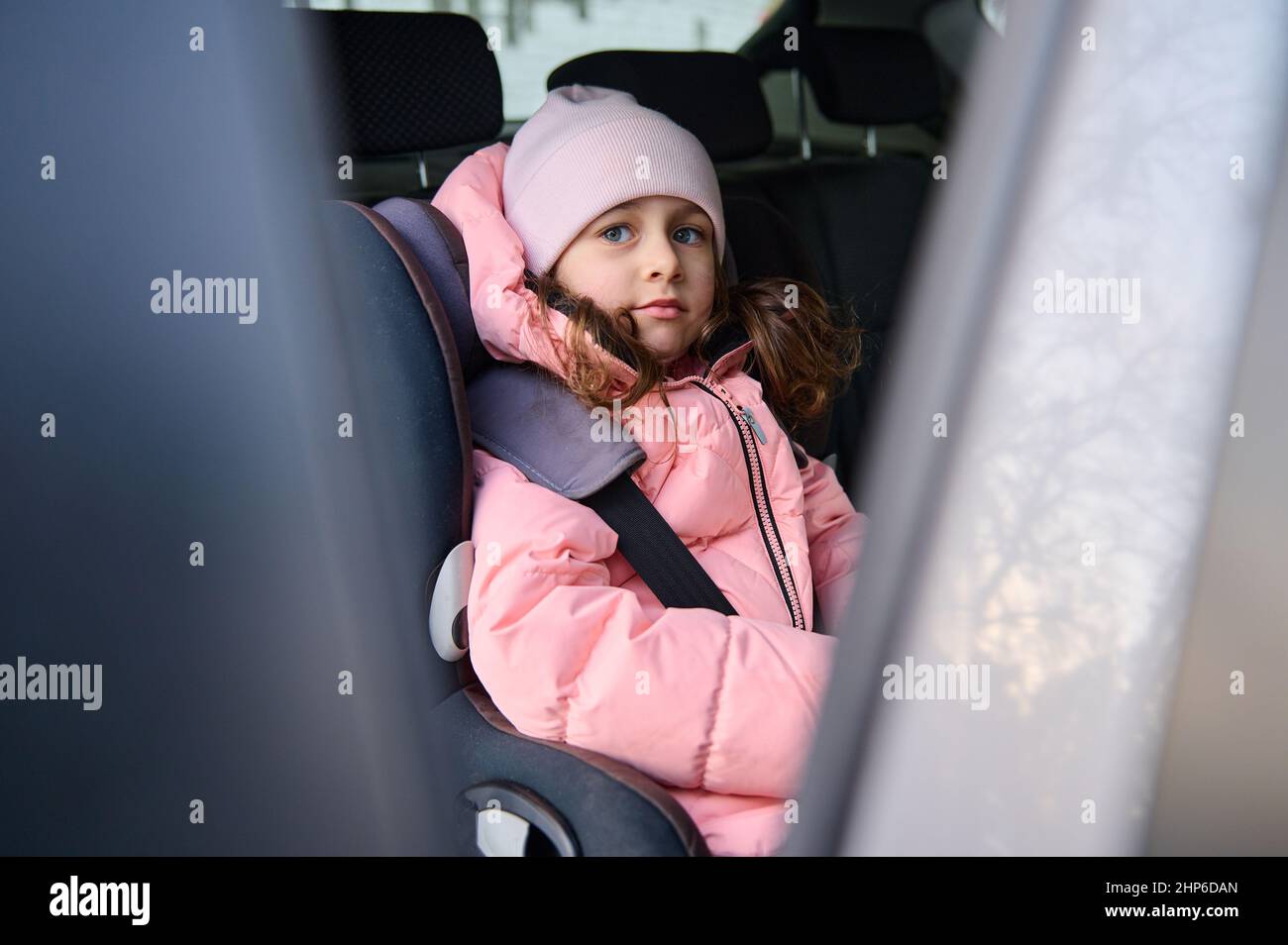 equipaje de ahora en adelante ballena Adorable niña, alegre niño con ropa de abrigo rosa sentado con un cinturón  de seguridad en el coche moderno durante un viaje familiar de invierno en Ca  Fotografía de stock - Alamy