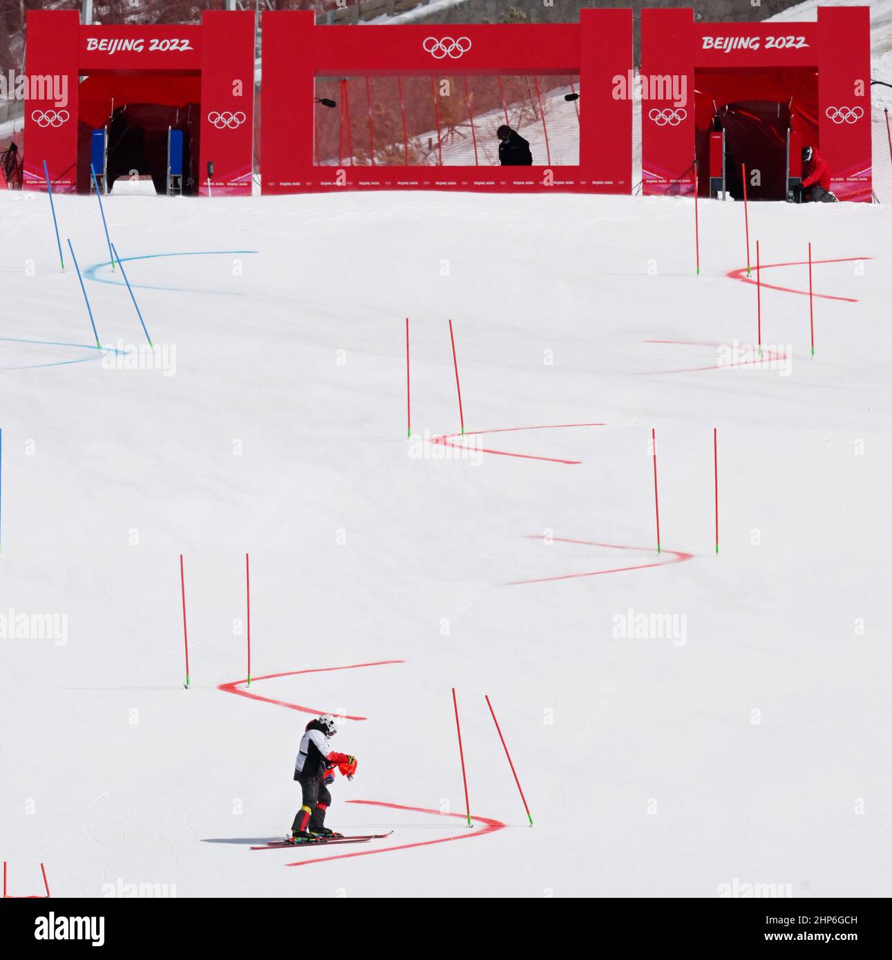 Pekín, China. 19th Feb, 2022. Un trabajador desmantela las puertas después de que el equipo mixto de esquí alpino paralelo de los Juegos Olímpicos de Invierno de Beijing 2022 se reprograman en el Centro Nacional de Esquí Alpino en el Distrito Yanqing, Beijing, capital de China, 19 de febrero de 2022. El viento ha obligado a cancelar el sábado el equipo mixto de esquí alpino olímpico de Pekín. Crédito: Zhang Chenlin/Xinhua/Alamy Live News Foto de stock