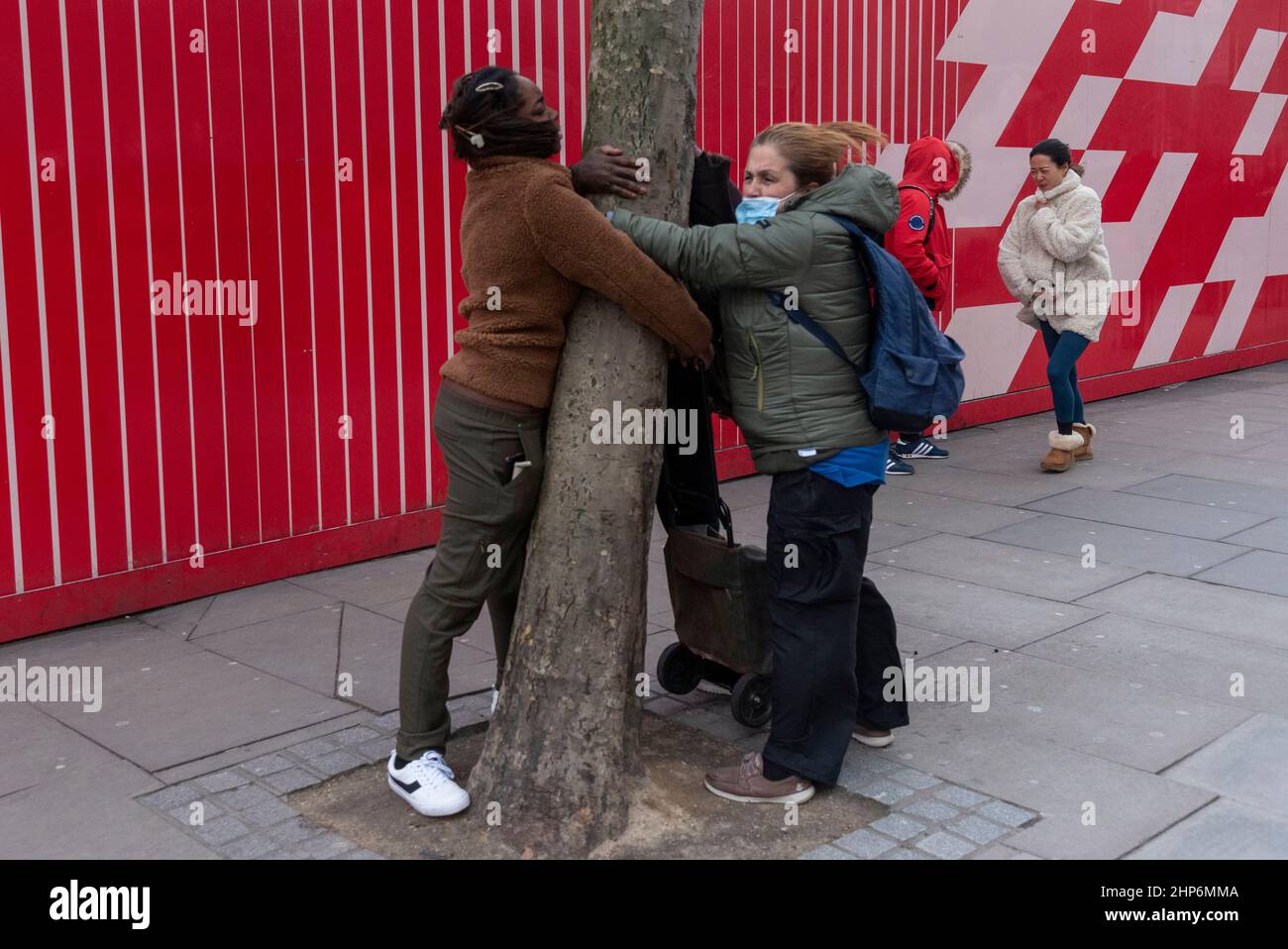 (220219) -- LONDRES, 19 de febrero de 2022 (Xinhua) -- Foto tomada el 18 de febrero de 2022 muestra a la gente aferrándose a un árbol durante los altos vientos de la tormenta Eunice en Londres, Gran Bretaña. Visto como una de las peores tormentas en tres décadas, Eunice ha traído un récord de viento a Gran Bretaña el viernes, matando a tres personas mientras causaba cortes masivos de energía, cancelaciones de vuelos y cierres de escuelas en todo el país. Una mujer en su 30s en el norte de Londres fue asesinada cuando un árbol cayó sobre su coche, un hombre en su 20s murió cuando su camión colisionó con un árbol caído en el sur de Inglaterra, y un hombre en su 50s en el noroeste de Inglaterra DI Foto de stock