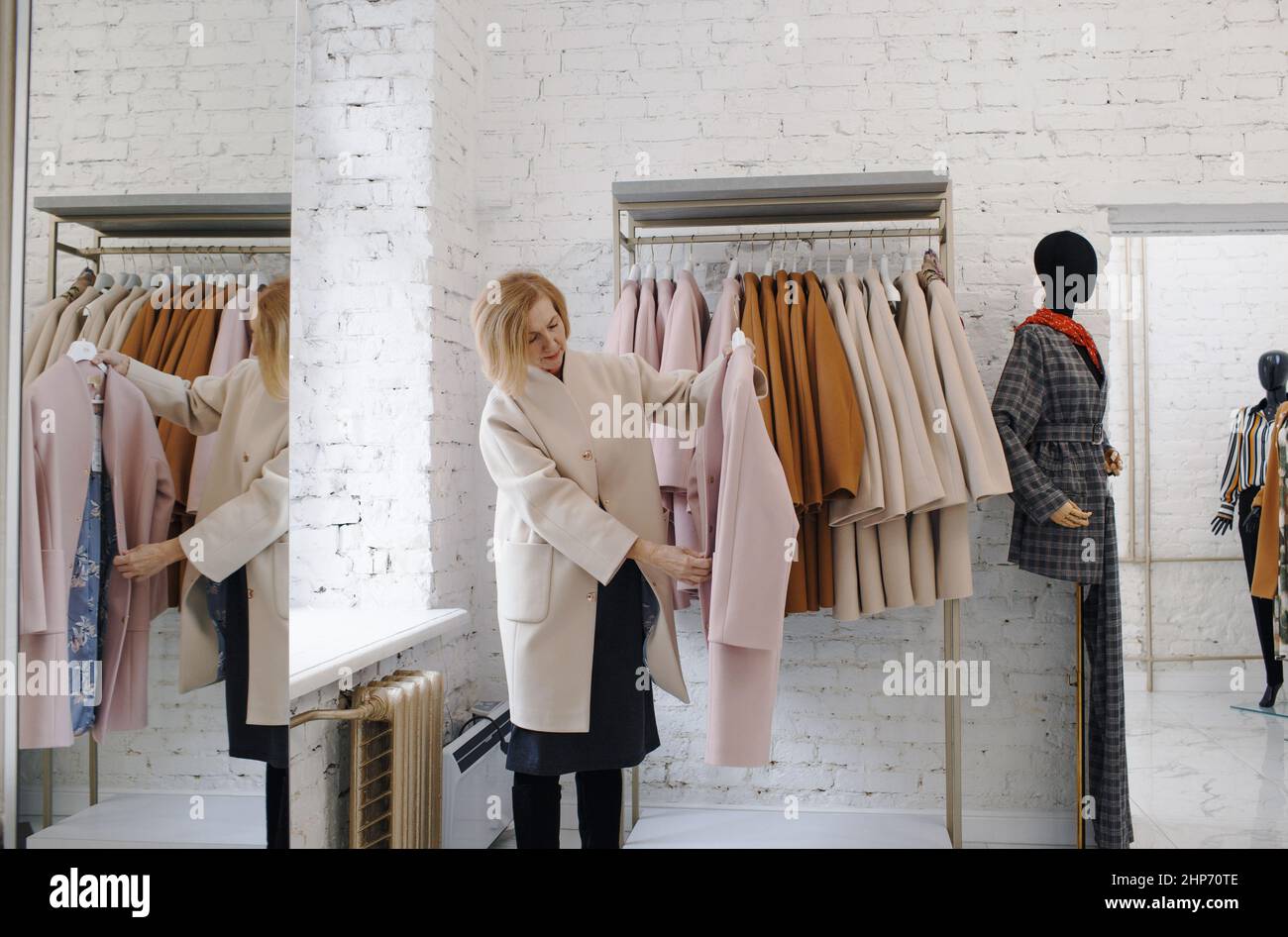 una mujer anciana en una tienda de ropa elige un abrigo. Compras comprar  ropa Fotografía de stock - Alamy