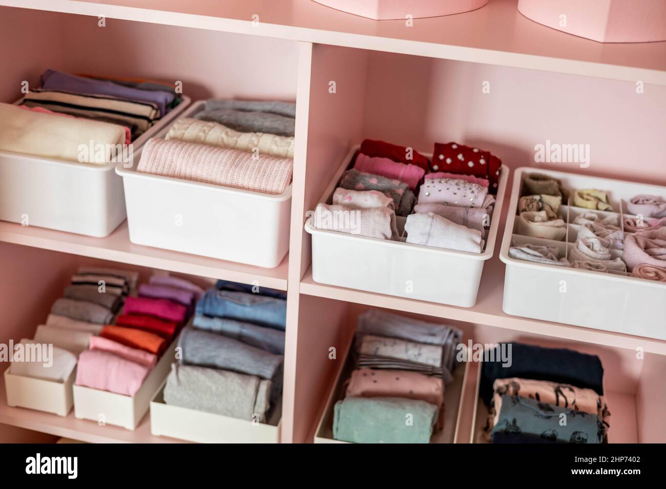 Primer plano estantes rosa hembra armario infantil con ropa cuidadosamente  plegada Marie Kondo almacenamiento vertical Fotografía de stock - Alamy