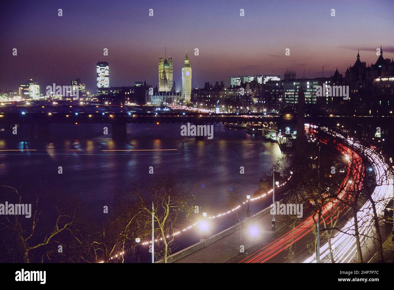 Vista elevada de las Casas del Parlamento y del Dique Victoria por la noche, Londres, Inglaterra, Reino Unido. Alrededor de los años 80 Foto de stock