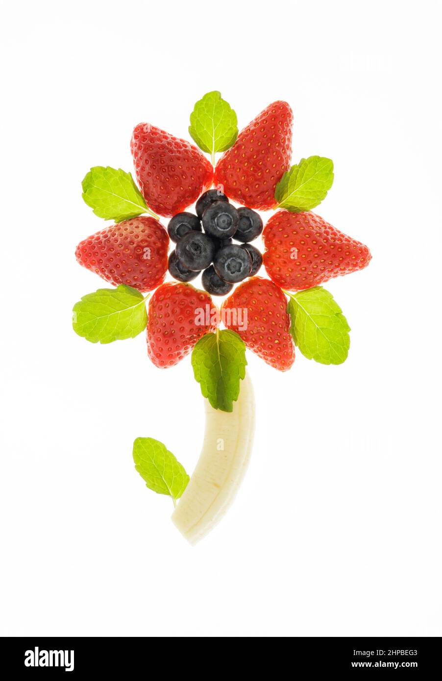 Arándanos frescos, fresas y plátanos dispuestos en forma de flor Foto de stock