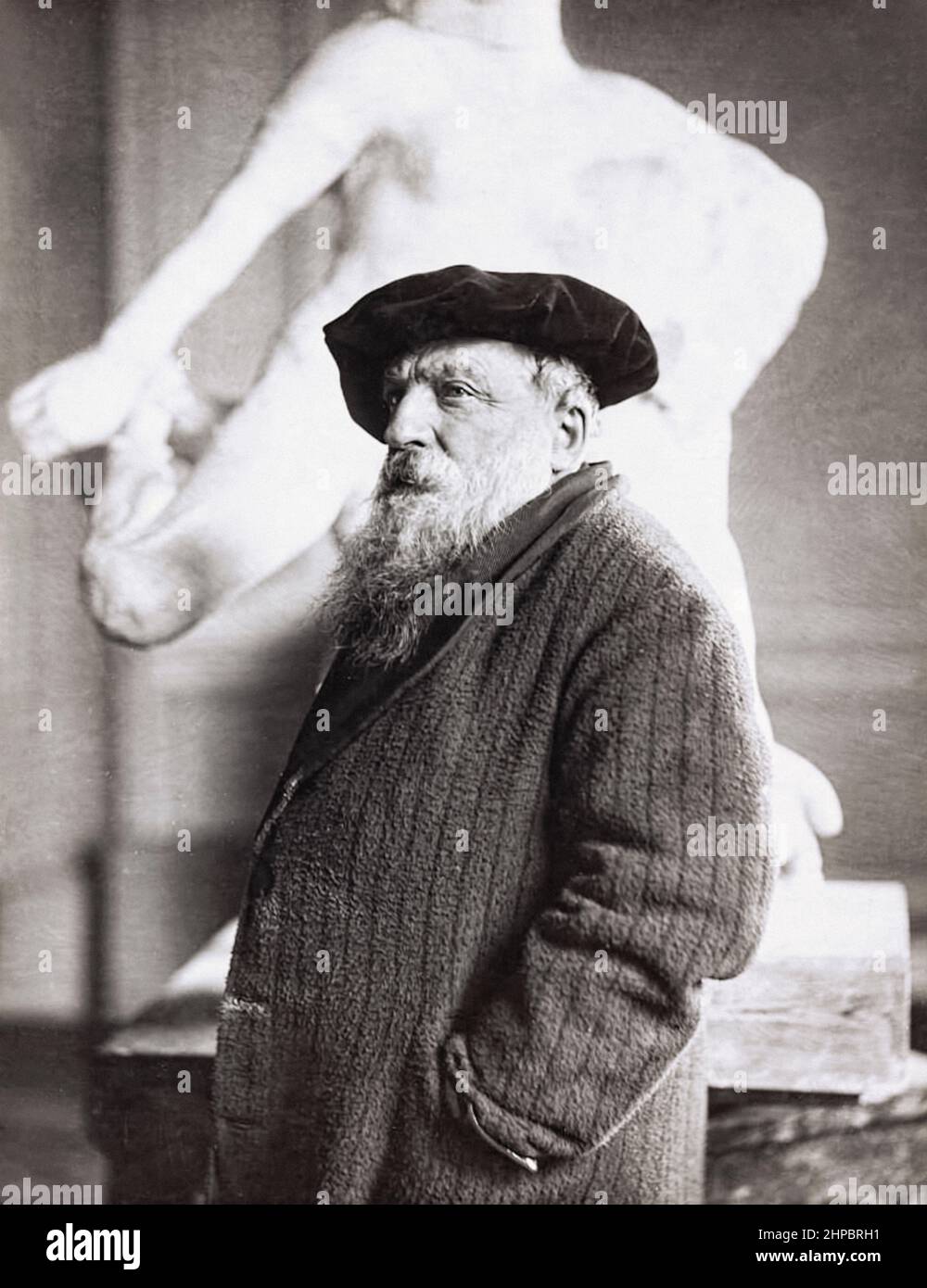 Auguste Rodin (1840-1917) escultor francés con su escultura El Idol Eterno (1893) en el fondo. Foto de stock