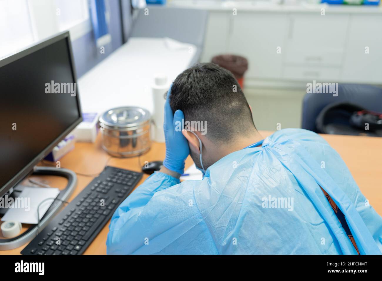 foto de un médico cansado con las manos en la cabeza en la clínica médica Foto de stock