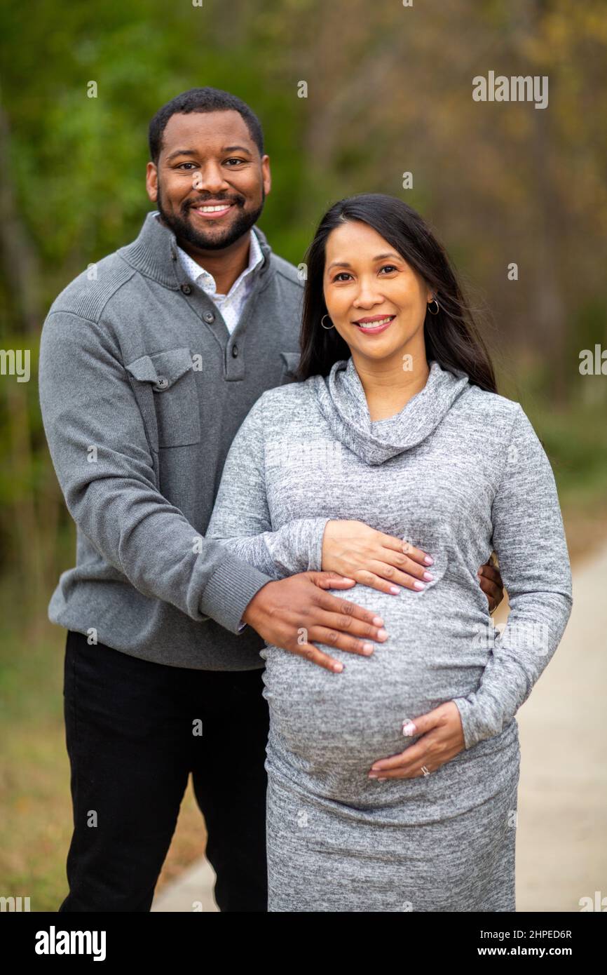 Retrato de una pareja mixta de razas que esperan a sus padres Foto de stock