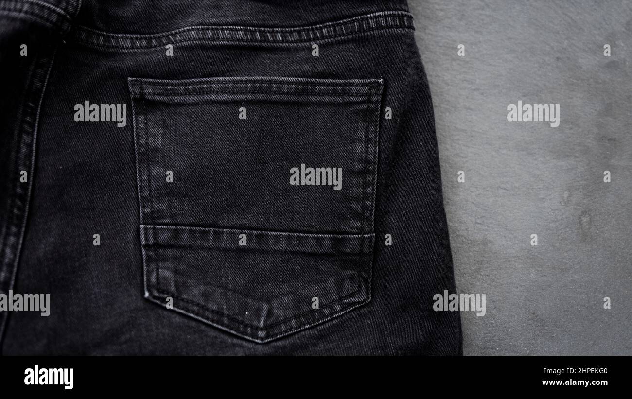 Jeans negros con bolsillo trasero sobre fondo negro. Jeans para hombre  Fotografía de stock - Alamy