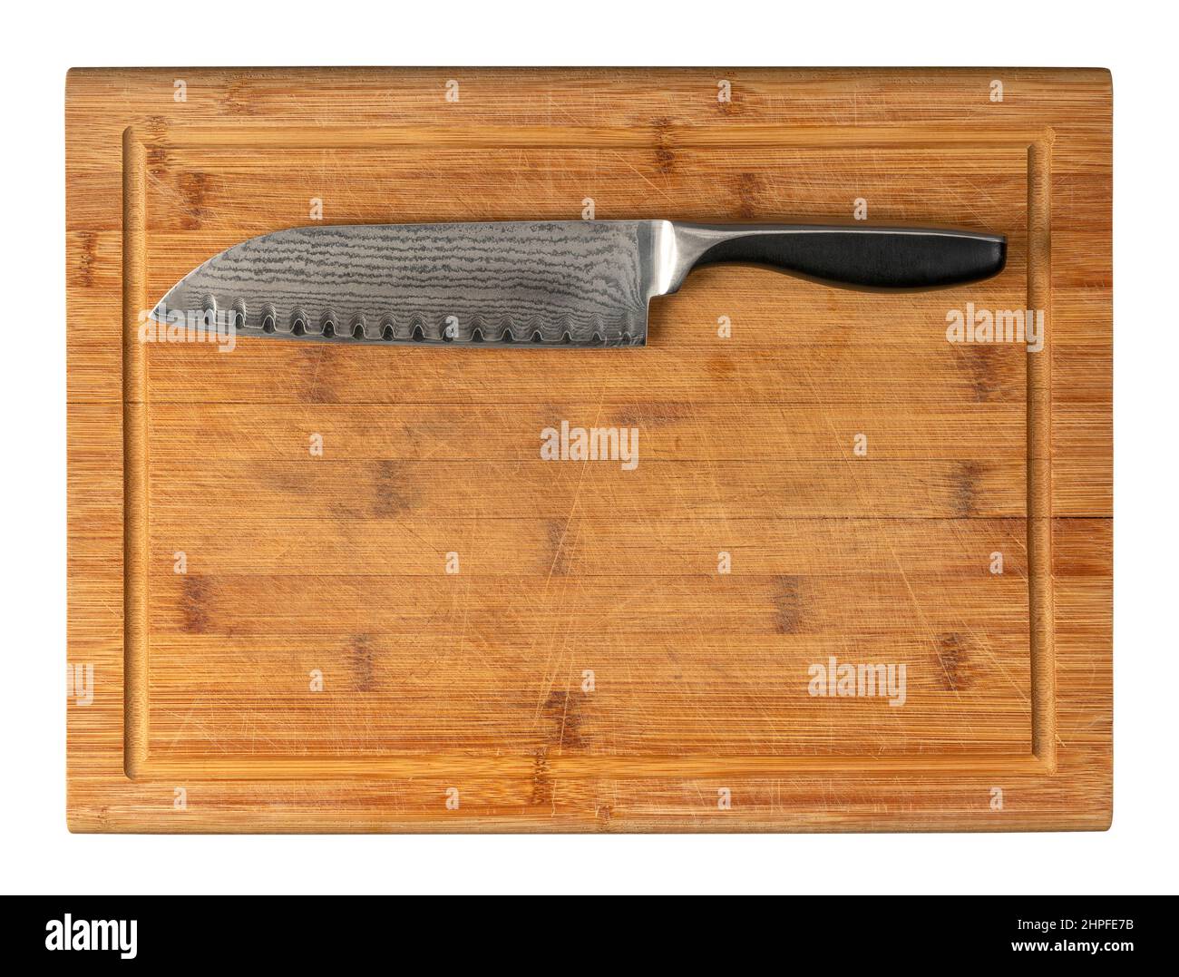 Cuchillo soldado con patrón sobre tabla de corte de bambú de madera en espalda blanca Foto de stock