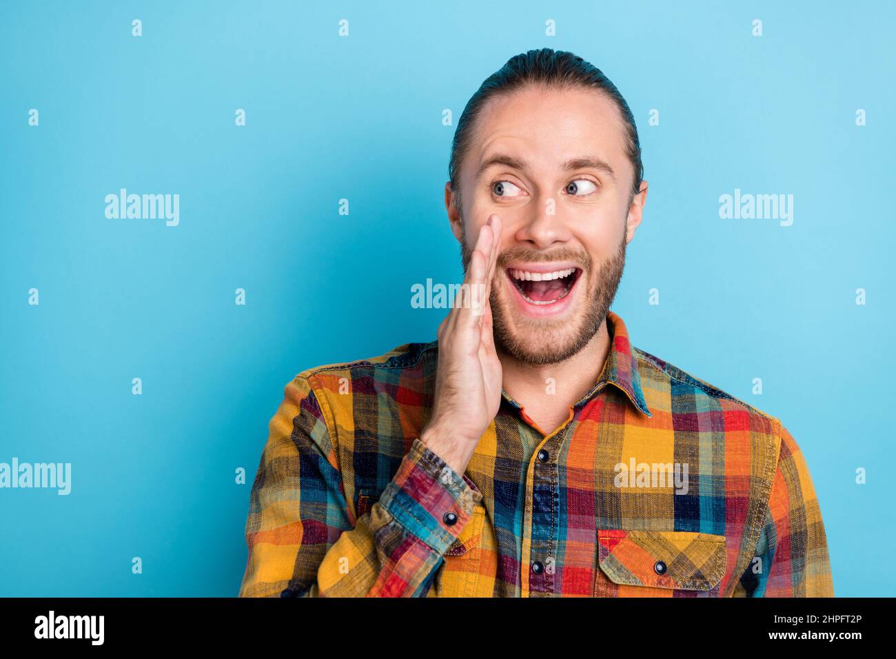 Foto de la morena millennial impresionado hombre look promo vestir camisa  amarilla aislado sobre fondo de color azul Fotografía de stock - Alamy