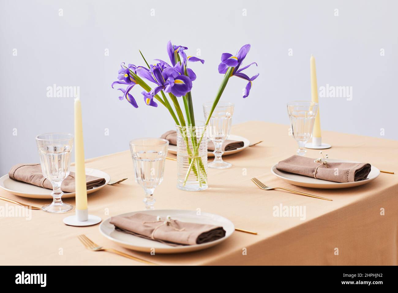 Imagen de fondo mínima de una elegante mesa de cena decorada con flores Iris para primavera, espacio de copia Foto de stock