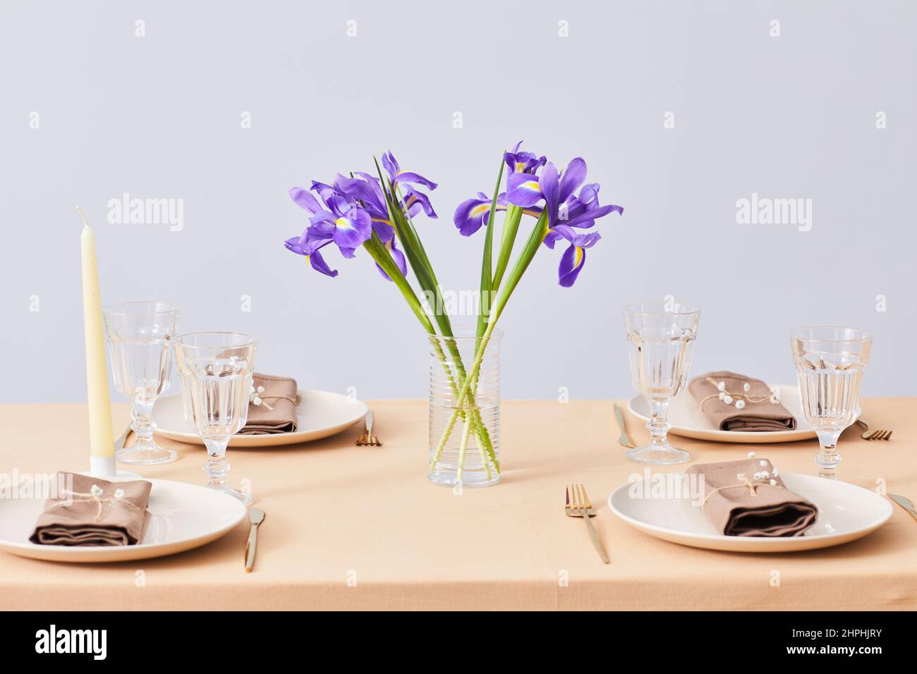Imagen de fondo mínima de la mesa de cena de primavera decorada con flores Iris, espacio de copia Foto de stock