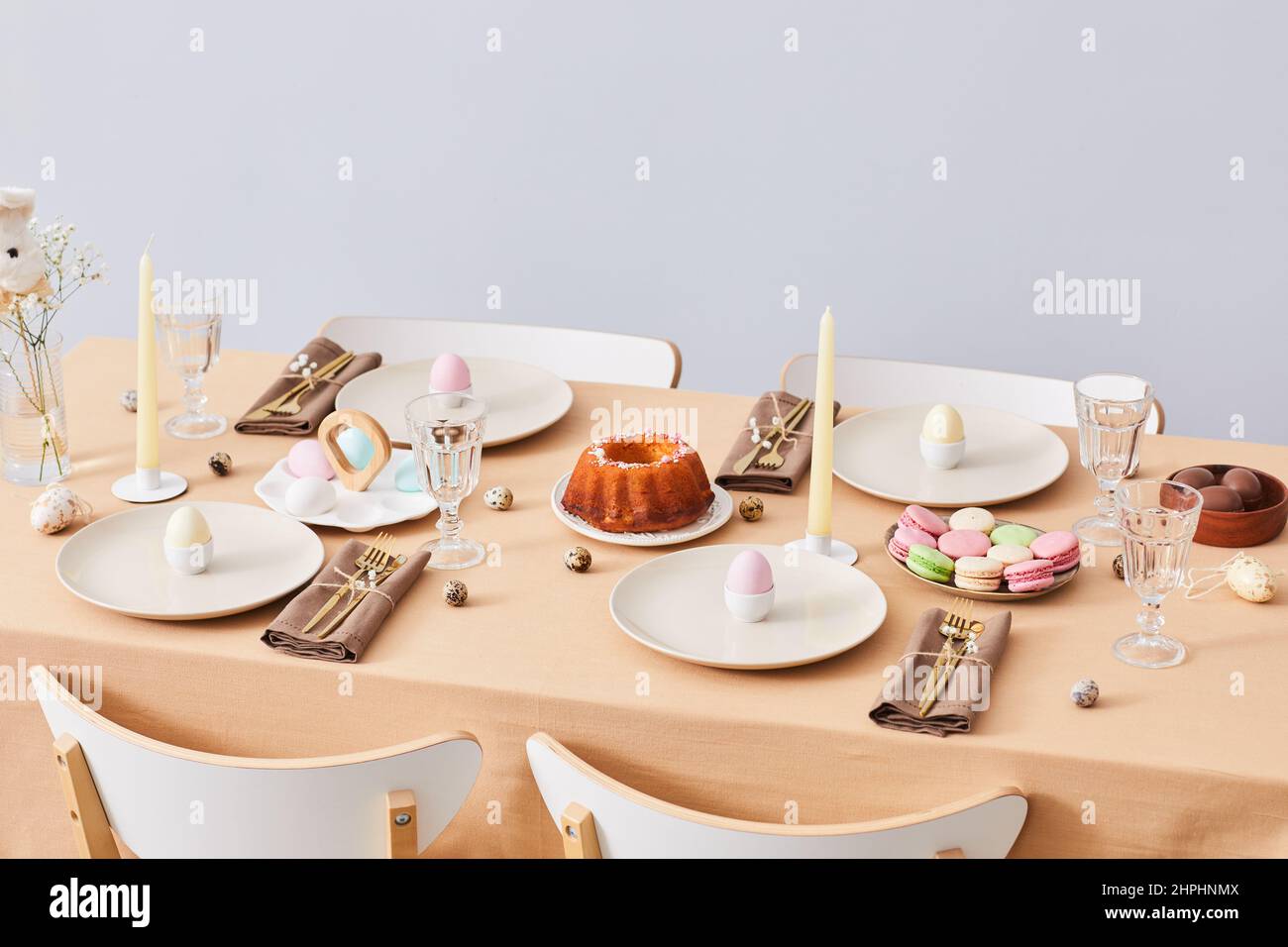 Imagen de fondo mínima de una elegante mesa de cena decorada para Semana Santa y Primavera, espacio para copiar Foto de stock