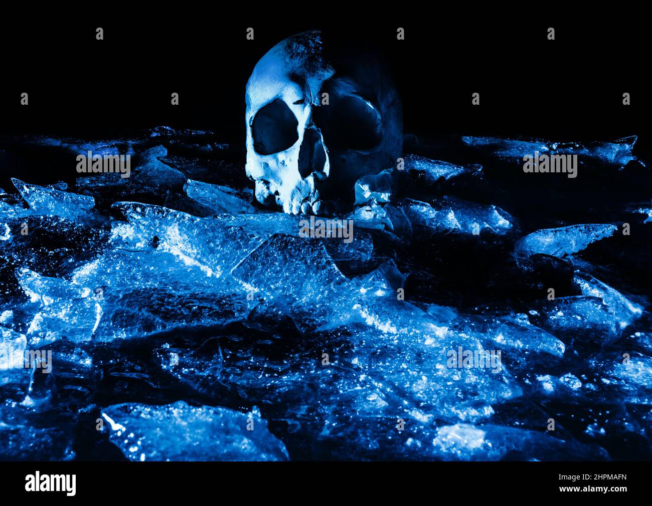 Terror foto aterradora de cráneo humano sobre terreno de hielo agrietado. Foto de stock