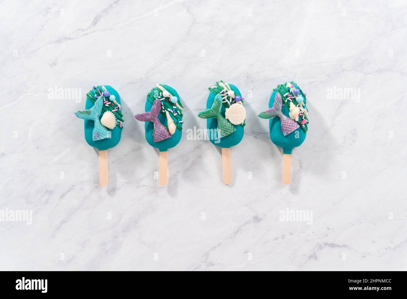 Capa plana. Las cakesicles de la sirena con chocolate regado, colas de la sirena de chocolate