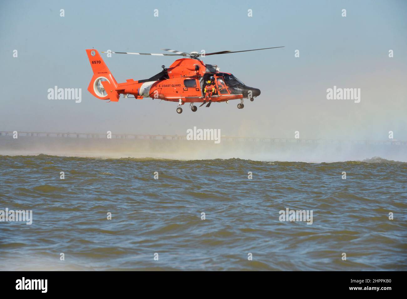 Técnico de Supervivencia de la Aviación de Primera Clase Kenneth Wood se prepara para desplegar desde un helicóptero MH-60 desde la Estación Aérea de Nueva Orleans el 15th de febrero, en el Lago Pontchartrain en Louisiana. Esta capacitación es para el despliegue seguro y la recuperación de un Técnico de Supervivencia Aérea durante las operaciones de rescate. (EE.UU Foto de la Guardia Costera por PA3 Riley Perkofski) Foto de stock