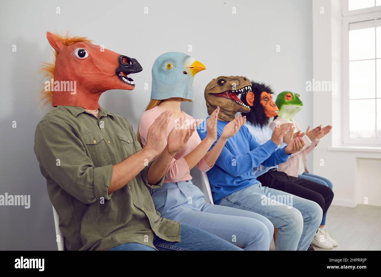 Grupo de personas en graciosas y extrañas máscaras de animales aplaudiendo  sus manos en la conferencia Fotografía de stock - Alamy
