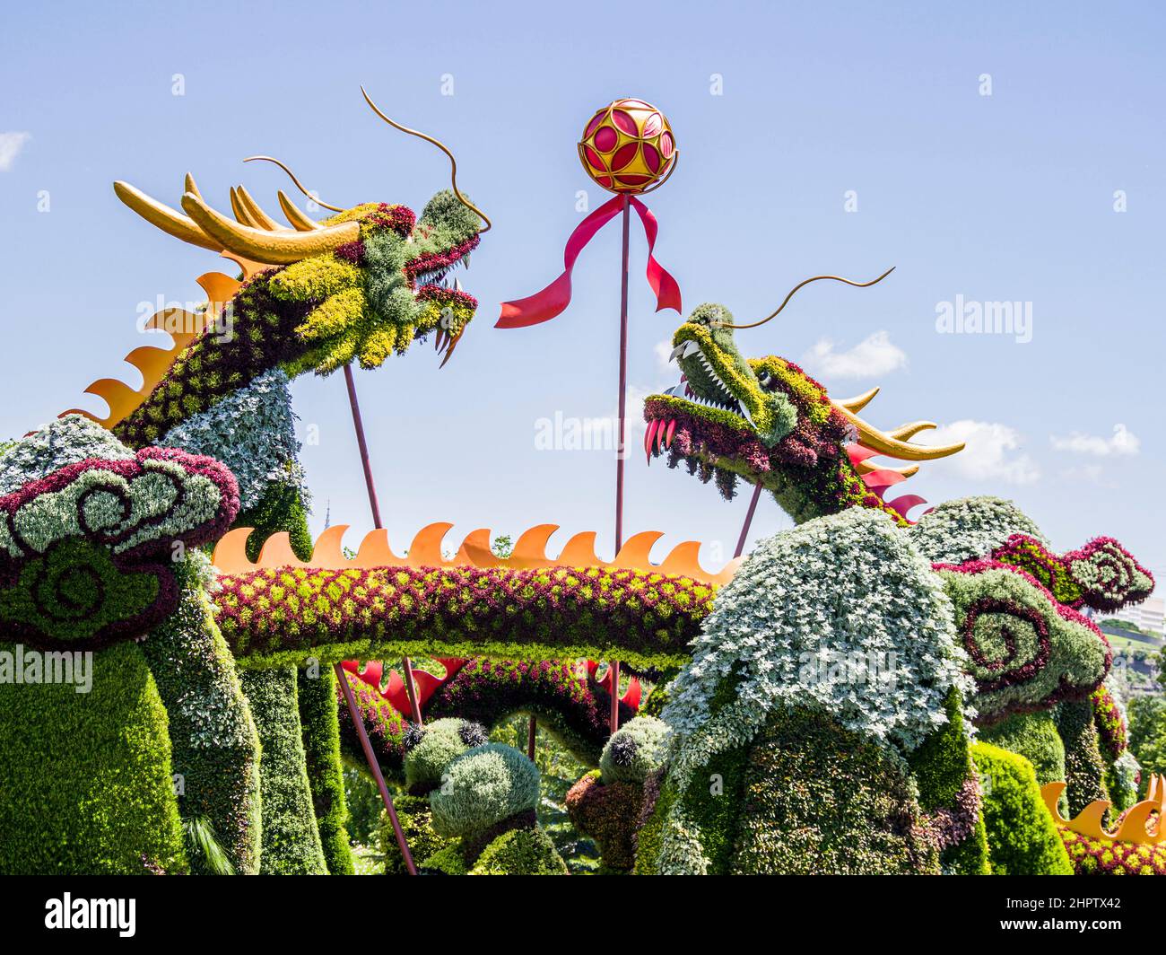 Escultura de plantas de dos dragones que luchan por una bola: Una escultura construida de plantas de varios colores representa dos criaturas con forma de dragón en forma de cuernos que viven por una bola o un palo. Parte de MosaiCanada que celebró el cumpleaños de Canadá en 150th. Foto de stock