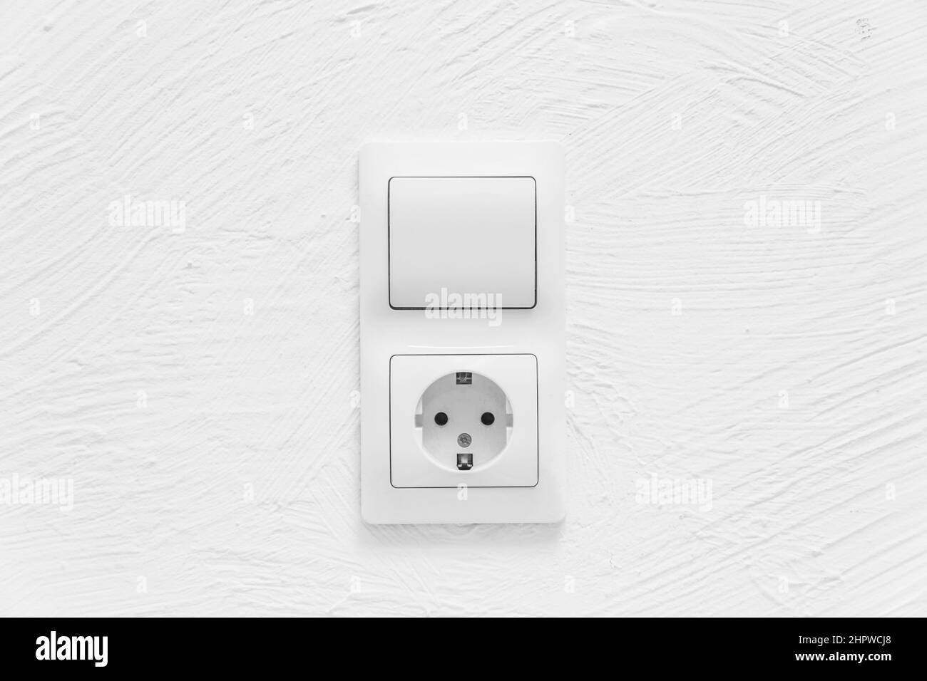 Enchufe y luz APAGAR Botón de encendido en el fondo de la pared blanca del interruptor de la casa. Foto de stock
